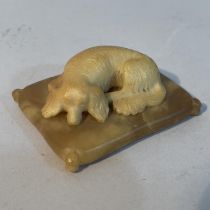 A soapstone carving of a spaniel recumbent on a cushion, 6.5cm x 5cm x 2.5cm high