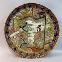 A large 19th century Japanese charger, the interior enamelled with a geisha standing on a backgammon