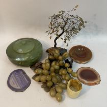 Two soapstone bundles of grapes, wire work model of a tree with green glass leaves and on rock base,