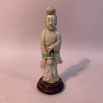 A Chinese jade carving of a deity or bijin standing with a basket of fruits in her hand