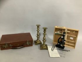 A Bijou cased microscope, a pair of brass candlesticks and a small suitcase