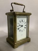 A brass carriage clock by Snow and Ashworth of Harrogate with a French movement, white enamel dial