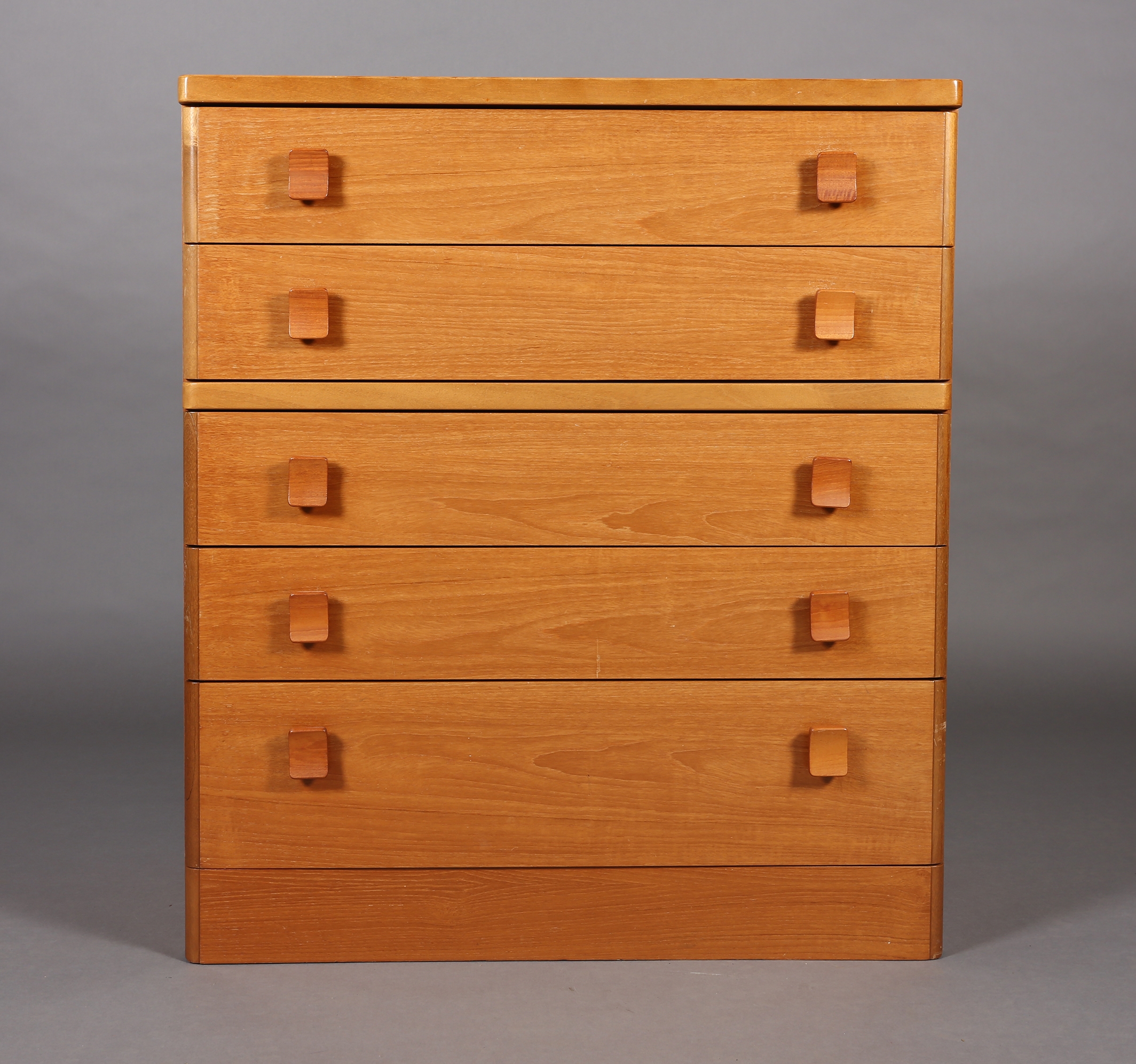 A Stag teak chest c1980s, of five graduated drawers with curved handles on a plinth base, 82cm