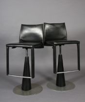 A pair of Frag black leather swivel bar stool on a conical pedestal and disc base