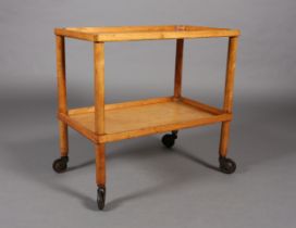 A 1940s laminated birch two tier trolley on rounded uprights and rubber rimmed wheels 65cm wide x