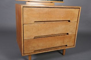 An early 1970s beech and mirrored dressing chest of three drawers on rounded and tapered legs,