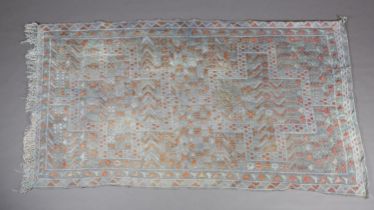A mid 20th century tapestry rug in pastel shades of blue and coral, with conjoined medallions with