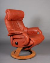 A Himolla swivel armchair upholstered in terracotta coloured leather