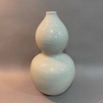 A Chinese blanc de chine double gourd vase, with reserves of chrysanthemum and clouds within stiff