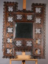 Architectural salvage: a Victorian oak framed mirror held within an H-shaped Gothic tracery frame