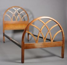 A mid 20th century elm single bed stead by Hypnos, the head and footboard of open semi-circular