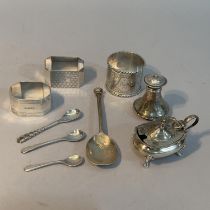 A small collection of silver napkin rings, condiment pieces and a commemorative Queen Elizabeth II