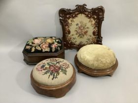 Two Victorian walnut footstools of circular outline with needlework and upholstered tops together