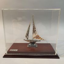 A white metal model of a Greek Yacht in sale with rigging, marked silver 950 and tests as silver, in