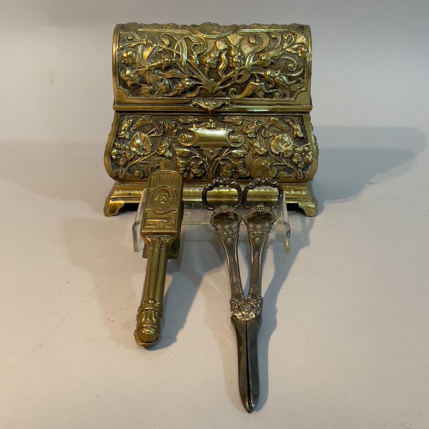 A 19th century ornate brass casket with hinged lid, the body moulded in high relief with thistles,