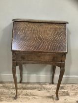 An early twentieth century oak drop front bureau with fitted interior on cabriole legs