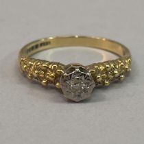 A single stone diamond ring in 18ct yellow and white gold, the brilliant cut stone, illusion set,