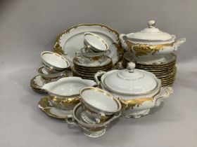 A Polish china dinner service by Walbrzych, white with moulded and gilded scrolled leafage