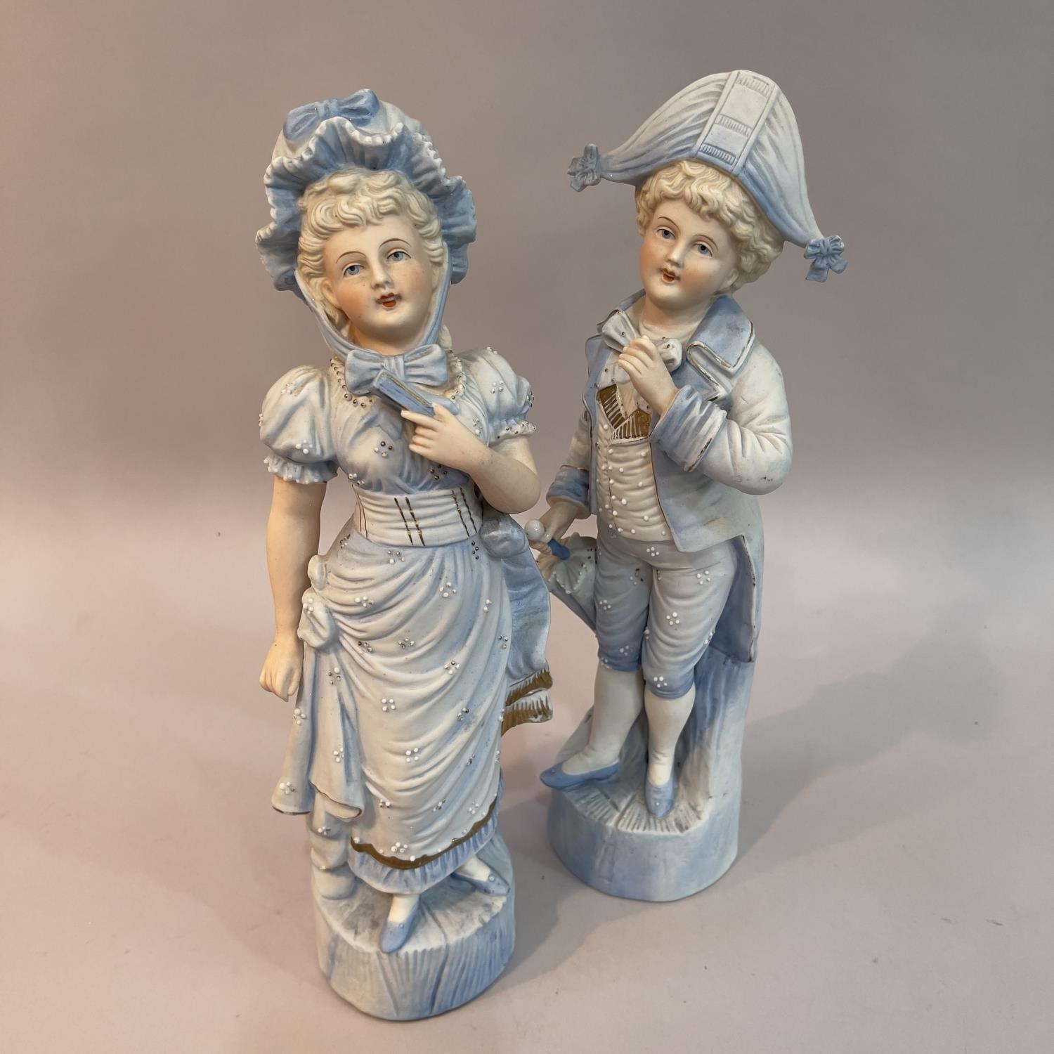 A pair of late 19th century continental pale blue figures of children dressed as a beau and