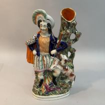 A mid 19th century Staffordshire pottery figural spill vase of a Scottish huntsman and hound, fallen
