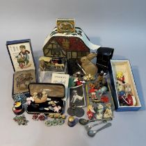 A money tin in the form of a tudor cottage together with a quantity of figurines and ephemera