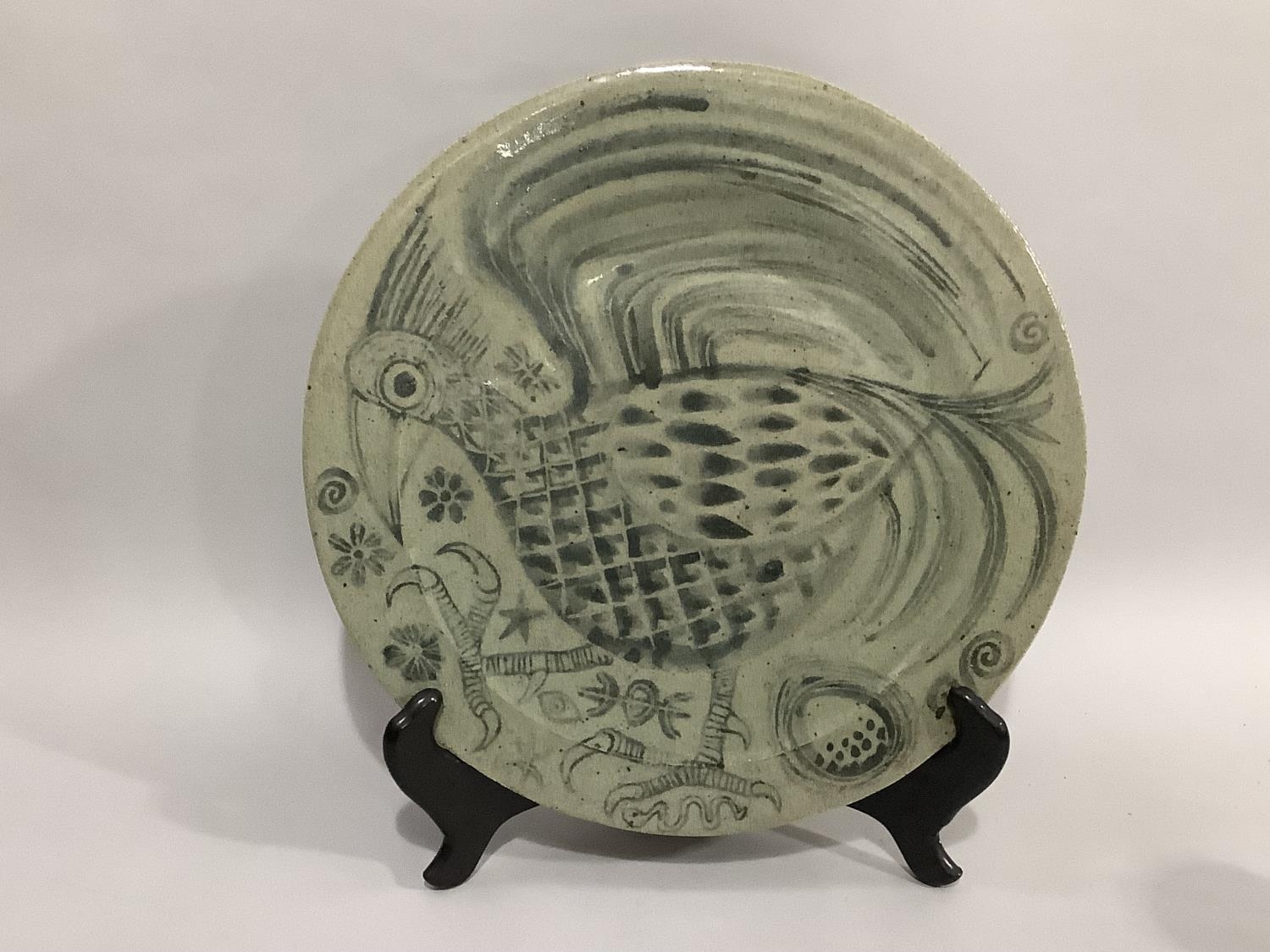 A 20th century stoneware charger, the ash glaze painted in grey with a bird, 46cm diameter