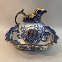 A Doulton Burslem toilet jug and bowl of blue and white, fox red and gilt flowering foliage, jug