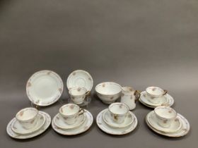 A Court China Queen Mary half tea service painted with rose buds, purple ribbon and gilt edging