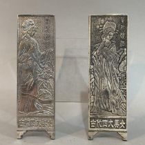 Two Chinese white metal panel weights the faces cast in high relief with traditional Chinese