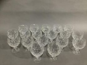 A set of eighteen cut glass red wine glasses