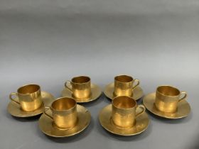 A Minton gilt coffee service for six embossed with foliage comprising coffee cans and saucers