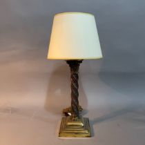 A brass table lamp having a Corinthian topped turned column on stepped base, with shade 35cm high