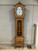 An oak longcase clock of Victorian style with three train movement chiming on rods, the dial with