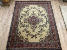 A Middle Eastern carpet, the ivory field having a central medalion, within a wine border, 366cm x