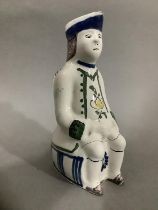 An 18th/19th century Delft toby jug, hand painted formed of a man atop a barrel, 19cm high