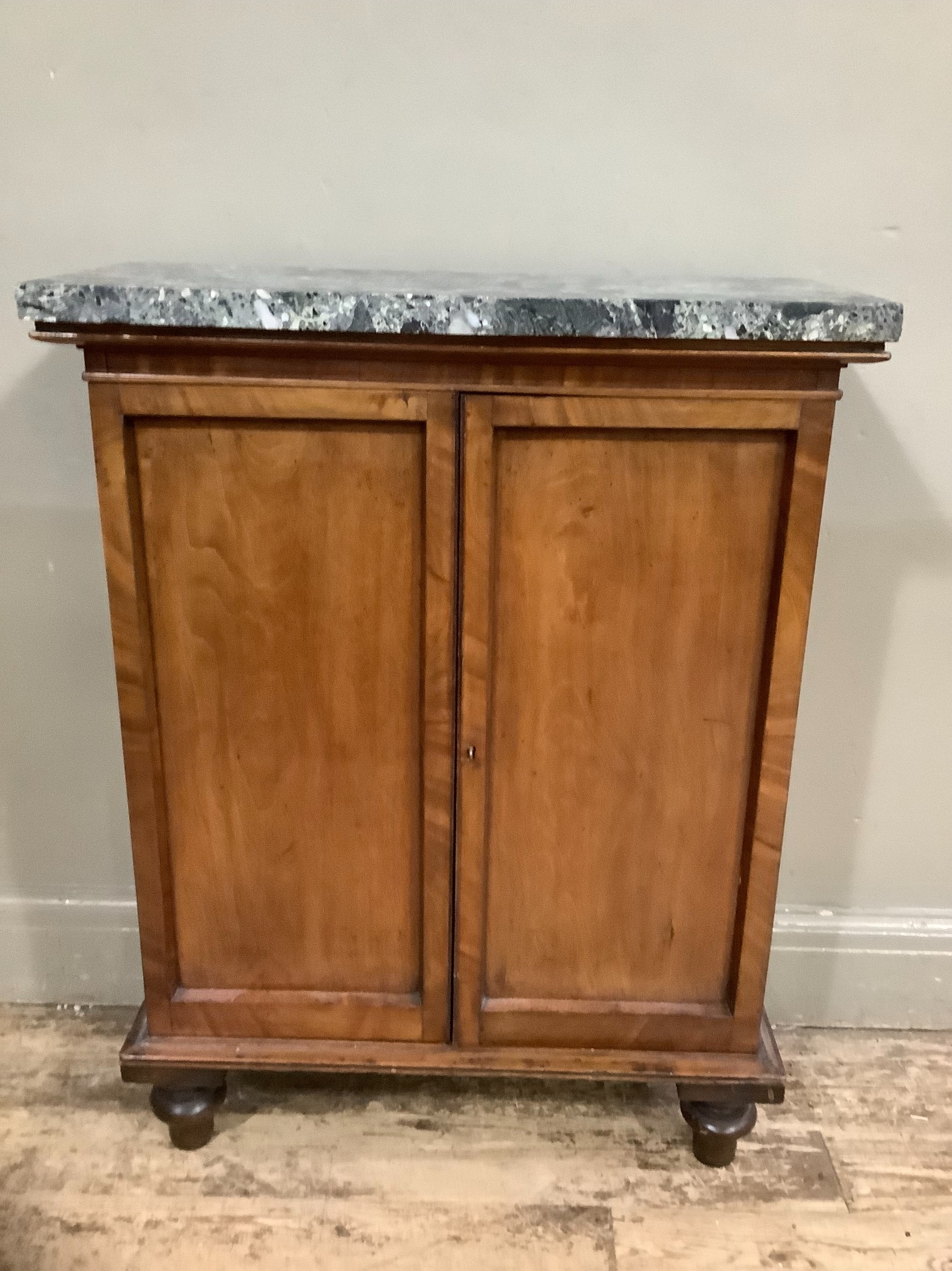 A Victorian marble topped mahogany side cabinet with two indented panel doors on turned feet, 67cm x