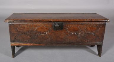 A MID 17TH CENTURY OAK BOARDED CHEST, having a two plank top over the carved front, incised