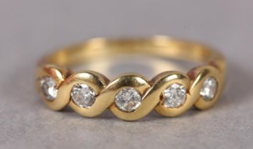 A DIAMOND FIVE STONE RING in 18ct gold, the brilliant cut stones rub over set in line, approximate