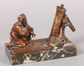 AN AUSTRIAN COLD PAINTED BRONZE CIGAR LIGHTER moulded as a snake charmer, the palm tree stamp