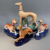 A PAIR OF MID 19TH CENTURY STAFFORDSHIRE POTTERY GREYHOUNDS, recumbent on an underglaze blue pen