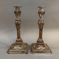 A PAIR OF 19TH CENTURY PLATED ON COPPER CANDLESTICKS, having vase shaped sconces embossed with