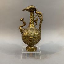 A 19TH CENTURY INDIAN BRASS EWER OR SURAHI having domed foliate cover, writhen neck with foliate