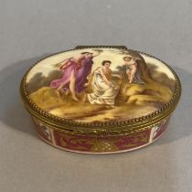 A LATE 19TH CENTURY PORCELAIN AND GILT METAL BOX, oval, the cover hand painted with cupid disarmed