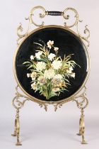 A VICTORIAN BRASS FRAMED AND MIRROR FIRE SCREEN WITH TURNED EBONISED HANDLE, the glass painted