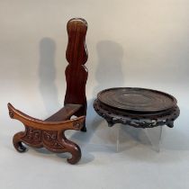 A CHINESE CARVED HARDWOOD PLATE STAND, 31.5cm high, together with a circular stand with pierced