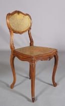 A VICTORIAN WALNUT AND GILDED BERGERE CANED SALON CHAIR, having an oval back with moulded encircling