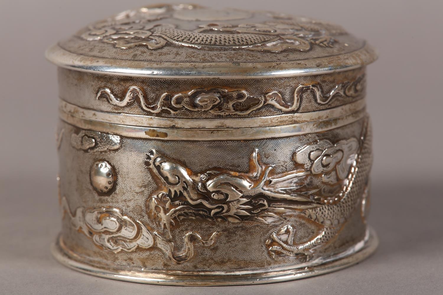 A CHINESE SILVER BOX AND COVER, cylindrical, embossed with dragons chasing the flaming pearl on a - Image 3 of 8