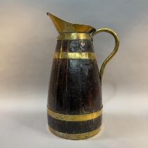 AN EARLY 20TH CENTURY OAK AND BRASS BOUND COOPERED JUG, 55.5cm high (Shipping category E)