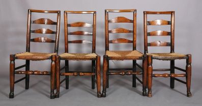FOUR EARLY 19TH CENTURY LANCASHIRE ASH LADDER BACK CHAIRS, the shaped top rails and curved bars