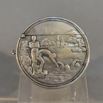 AN EARLY 20TH CENTURY SILVER VESTA, of circular form embossed to one side with swimmers in a river